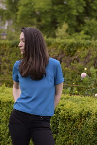 Young woman standing by plants