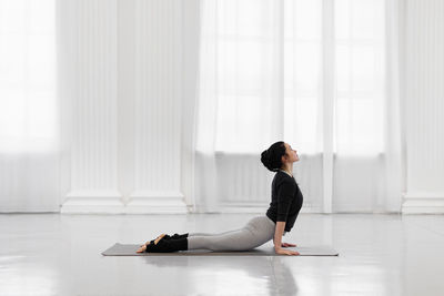 Side view of man sitting on floor