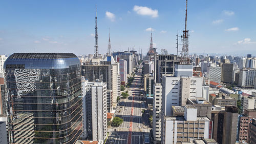 Aerial view of buildings in city against sky