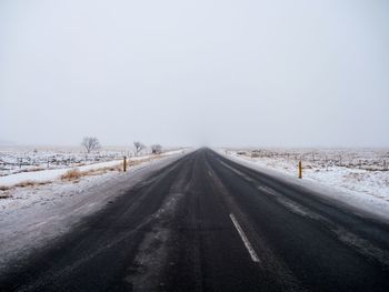 Road against clear sky during winter