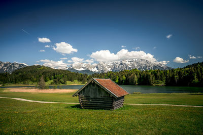 Wooden house on field against sky
