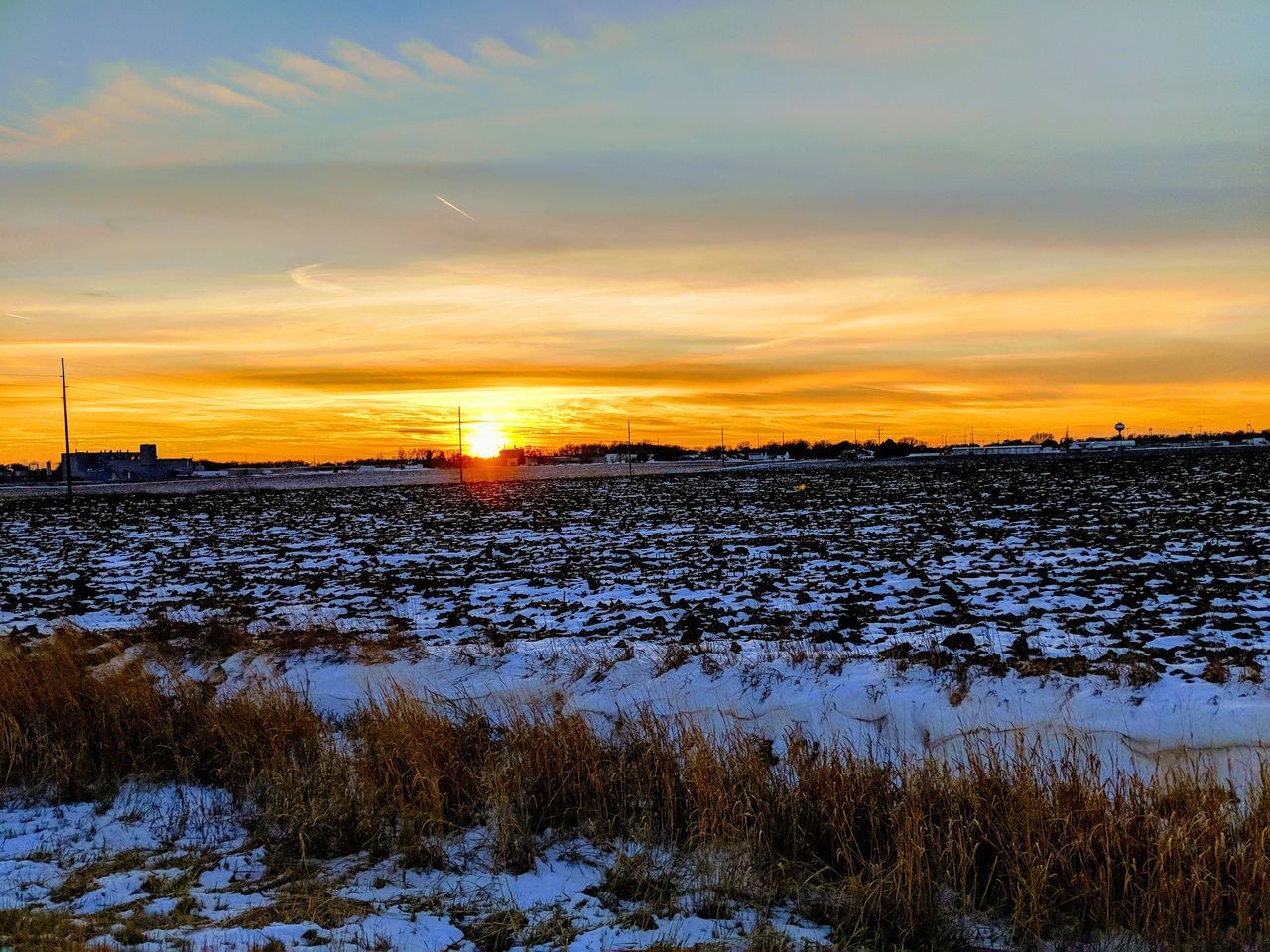 SCENIC VIEW OF SNOW COVERED FIELD DURING SUNSET