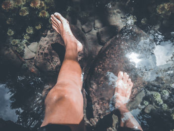Low section of woman swimming in water
