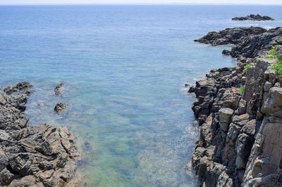 High angle view of rocks in sea against sky