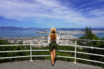 Rear view of woman looking at sea against sky