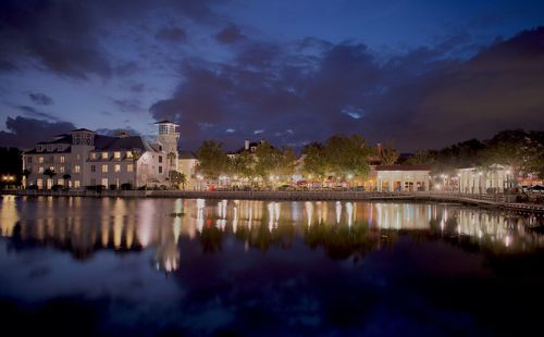 Reflection of buildings in lake against sky at night