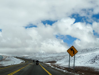 Road signs on landscape against sky