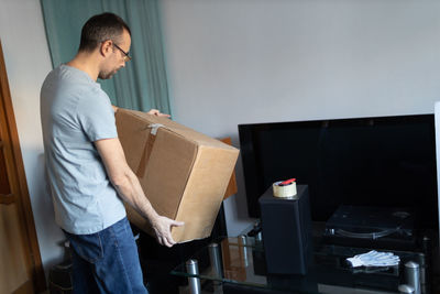 Side view of man sitting on sofa at home