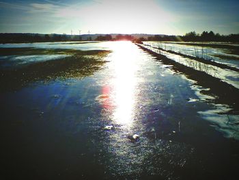 Scenic view of river against sky at sunset