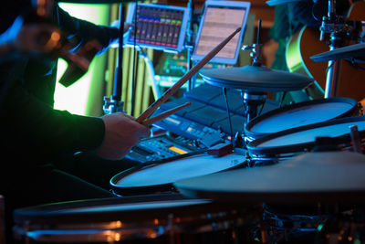 Cropped hand playing drum during music concert