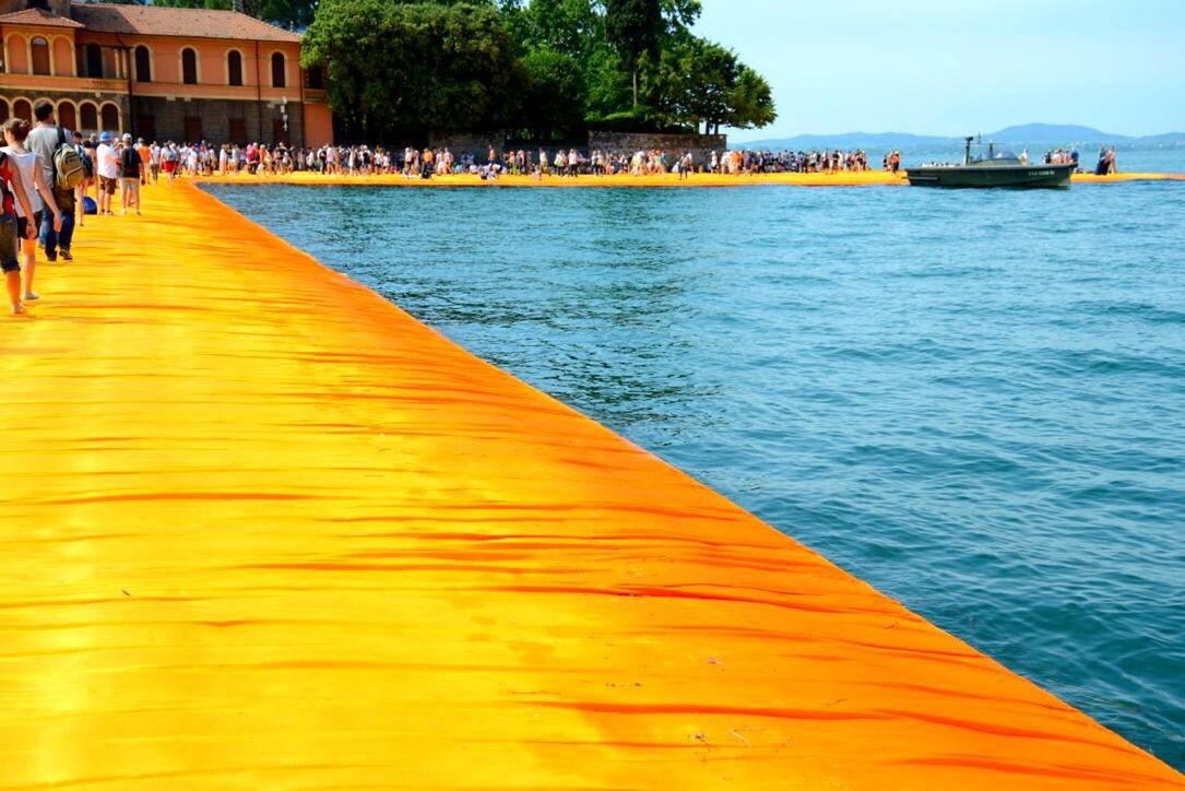 water, building exterior, built structure, architecture, incidental people, sea, waterfront, blue, pier, person, lifestyles, outdoors, leisure activity, tree, rippled, sky, city, large group of people