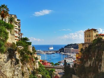 Panoramic shot of town by sea against blue sky