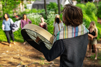 Rear view of friends standing in park