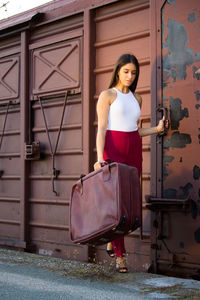 Portrait of woman standing against door