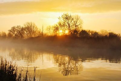 Scenic view of lake against sky during sunset