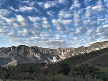 Scenic view of mountains against cloudy sky