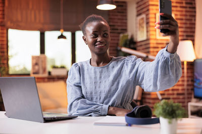 Portrait of young businesswoman working at table