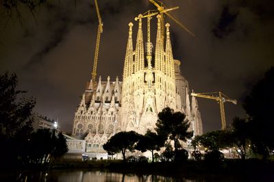 Low angle view of illuminated buildings against sky at night
