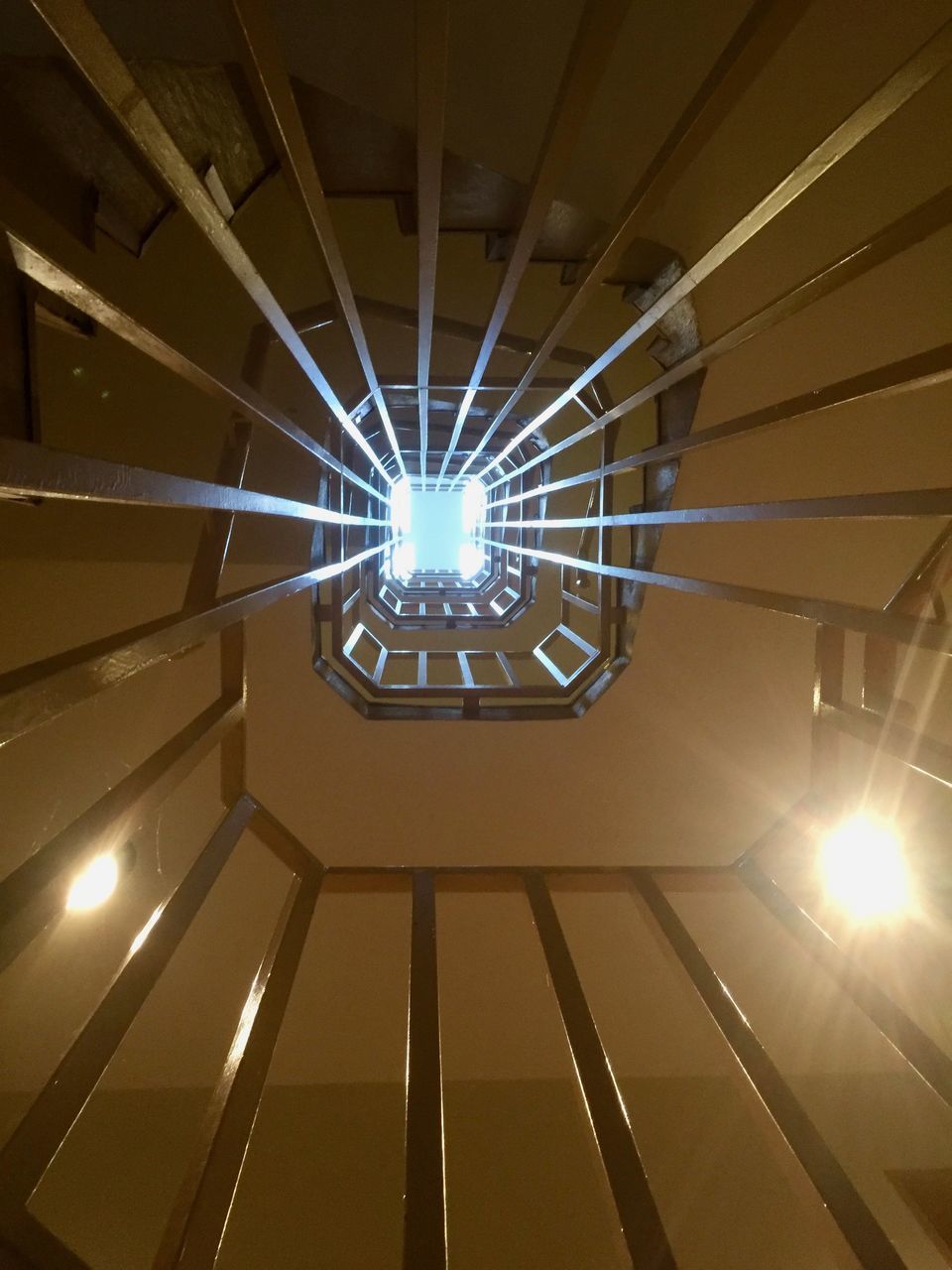 LOW ANGLE VIEW OF ILLUMINATED LIGHT HANGING FROM CEILING IN BUILDING