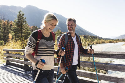 Austria, alps, happy couple on a hiking trip crossing a bridge