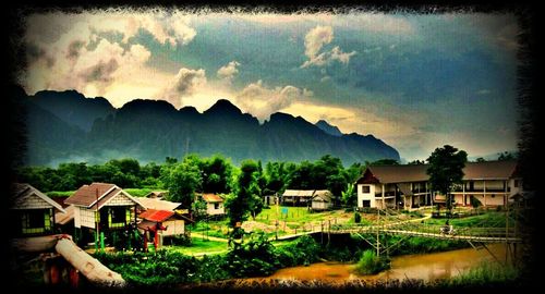 Houses in town against cloudy sky