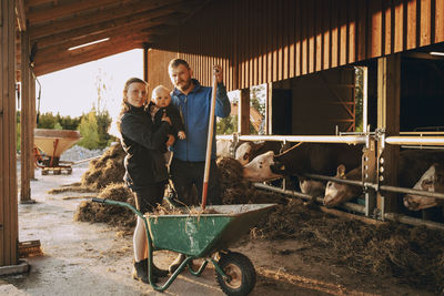 Portrait of parents with toddler son standing in stable