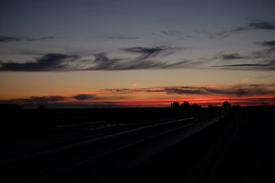 Silhouette road against sky during sunset