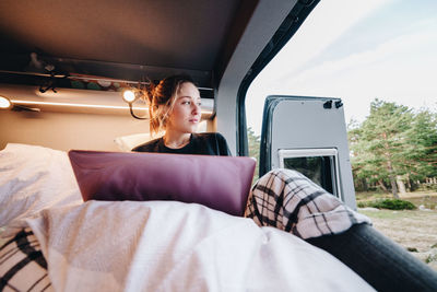 Young woman using laptop in camper