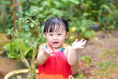 Portrait of cute baby girl sitting on field