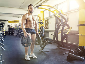 Close-up of muscular man holding equipment at gym
