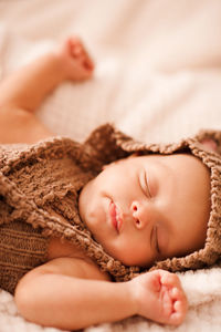 Cute newborn baby boy sleeping in bed