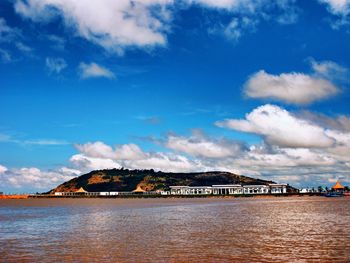 Scenic view of sea by buildings against sky