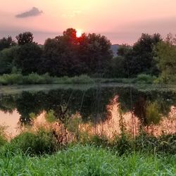 Scenic view of lake against sky at sunset