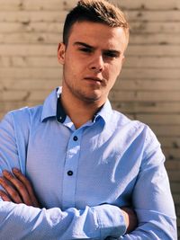 Portrait of man standing against wall