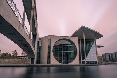 Bridge over river in city against sky