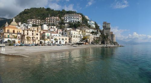 Buildings by sea against sky in city