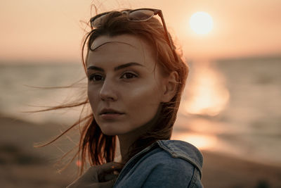 Portrait of woman against sea during sunset