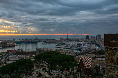 High angle view of buildings and sea against sky at sunset