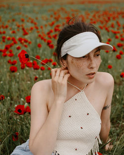 Portrait of young woman sitting on field