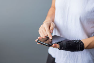 Midsection of man using mobile phone