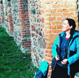 Woman standing against brick wall