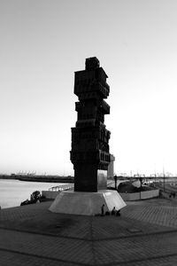 Built structure on pier by sea against clear sky
