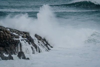 View of waves breaking on rocks