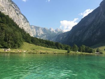 Scenic view of lake by mountains against sky