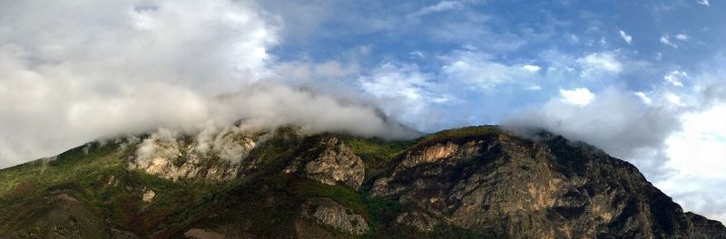 Low angle view of clouds over mountain