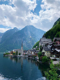 Panoramic view of river amidst buildings and mountains against sky