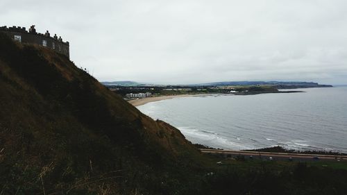 Scenic view of sea by city against sky