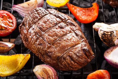 Juice beef steak on a barbecue grill with vegetables