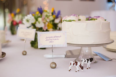 Close-up of wedding cake by text on table