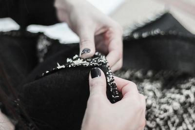 Women's hands with a beautiful manicure in the sewing process.